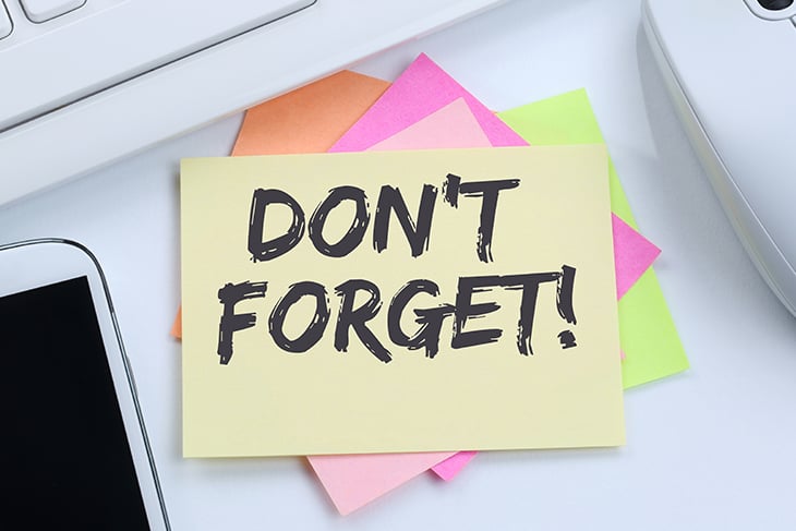 Sticky note on keyboard with "don't forget" written on it